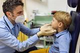 GP examining a young boy's throat