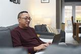 Man sat on sofa using a laptop