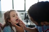 GP examining a young girl's throat