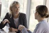 Female GP trainer in discussion with younger female colleague