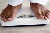 Close up of man's feet standing on scales